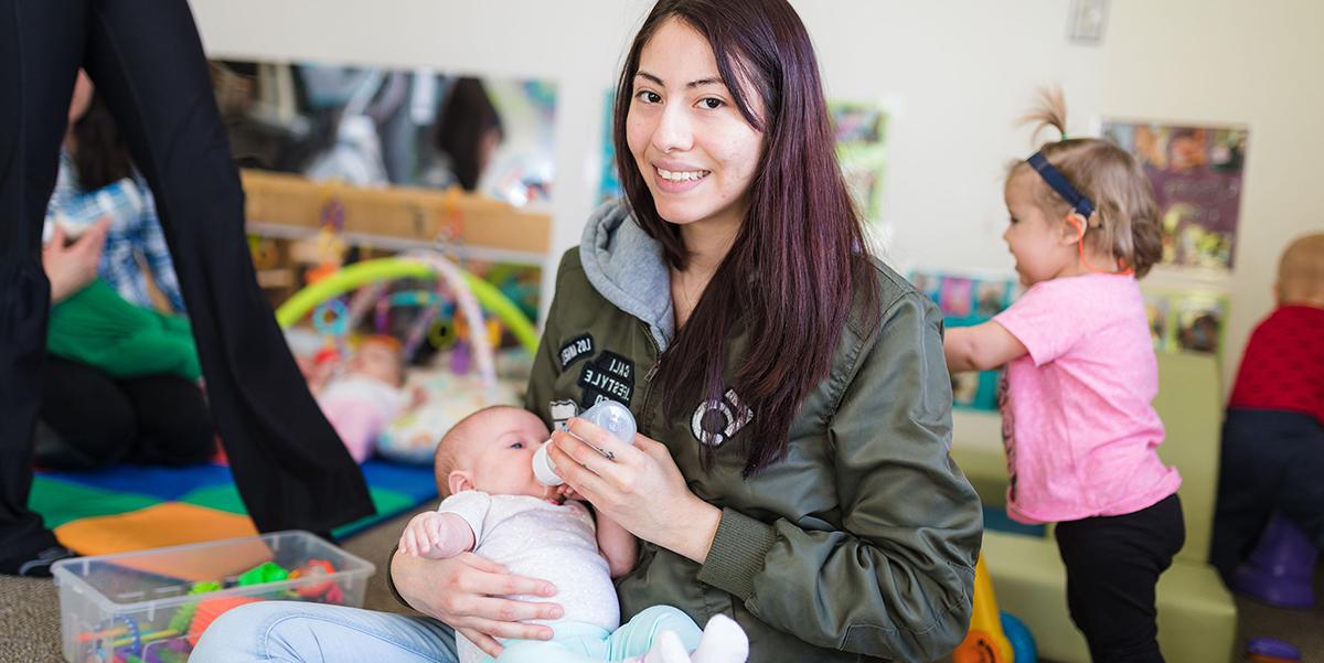 A student feeds a baby