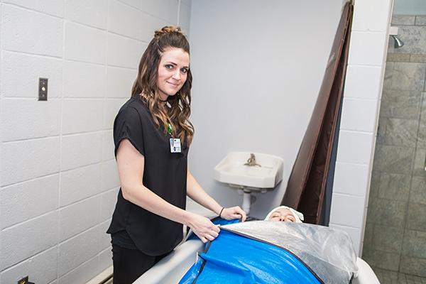 A cosmetology student works on a mannequin